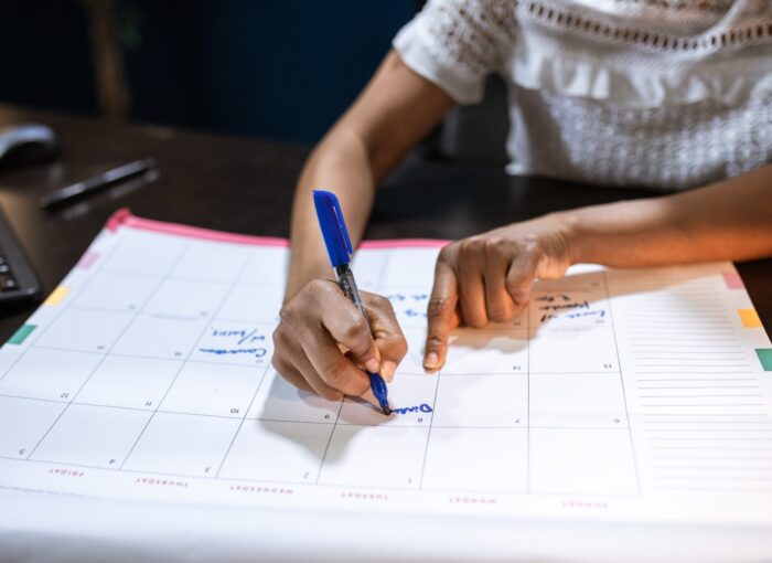 person writing all medellin events on his calendar