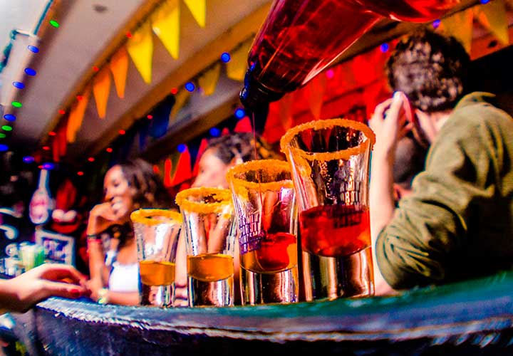 the counter of a bar with a mix of drinks on it